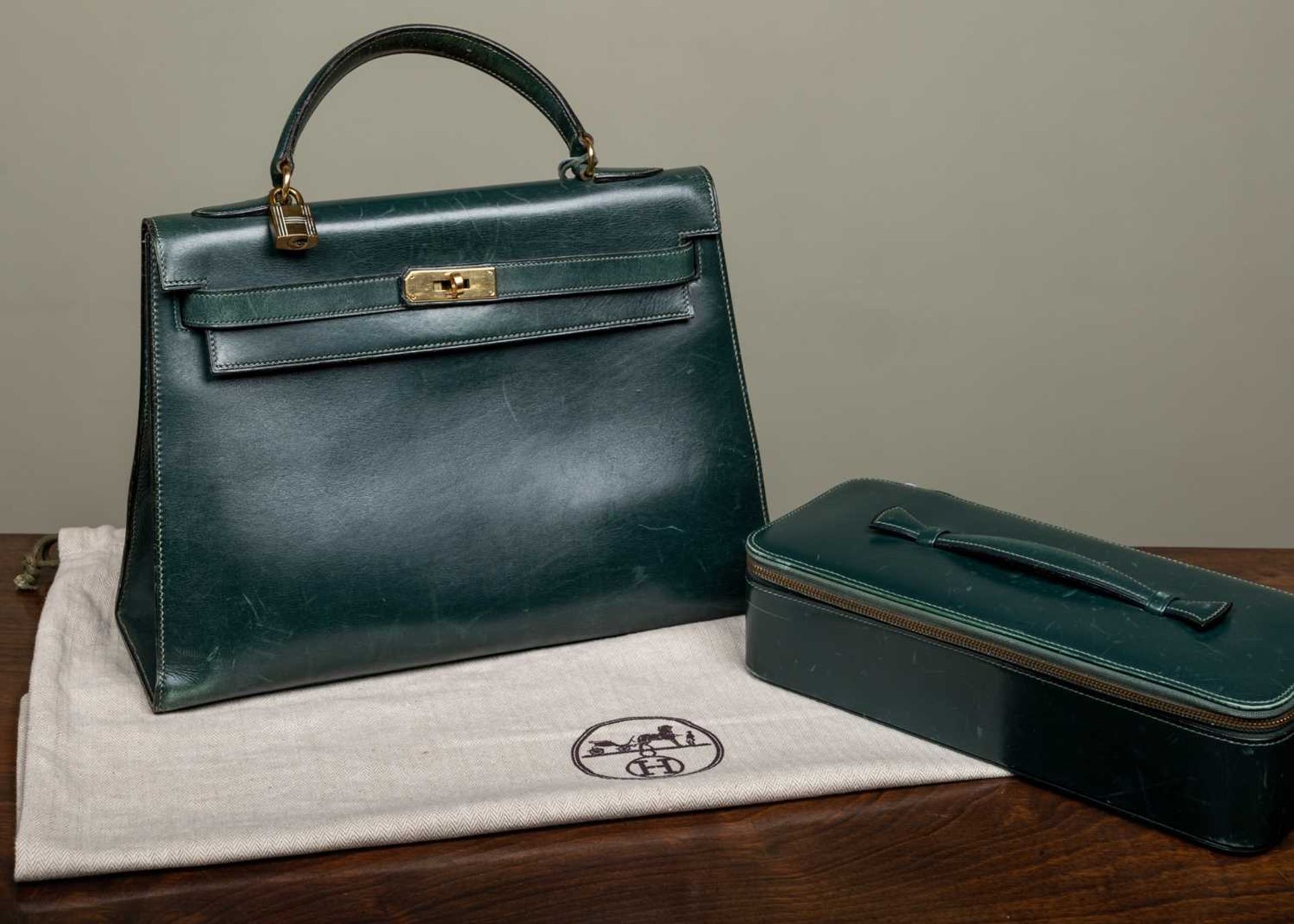 A Hermès 'Kelly' green leather handbag and matching jewellery case, the bag 33cm wide at the base