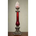 A 19th century bronze and red glass oil lamp base with octagonal baluster stem over a cast base with