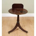 A 19th century mahogany tripod table with raised back, moulded brass edge, the splaying legs