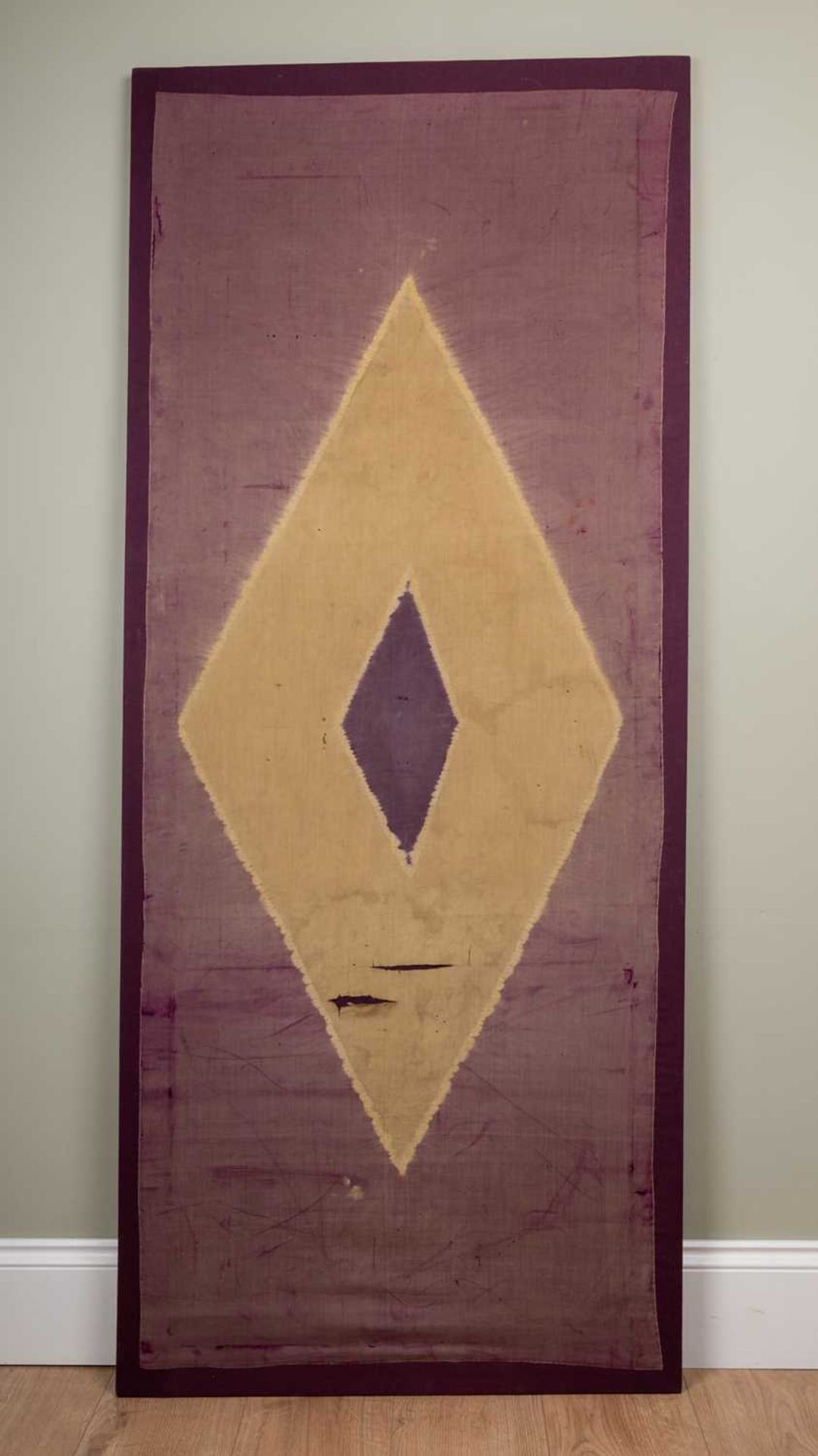 An Indonesian silk lawn panel with central diamond on a purple ground, 20th century, mounted on a