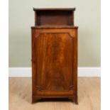An early 19th century mahogany music cabinet with small shelf on ring turned supports above, the