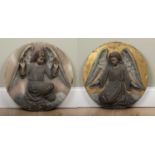 A pair of carved alabaster roundels depicting angels, one on a painted gold ground, both with