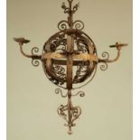 An early 20th century wrought iron hanging chandelier, the central globe with four branches and