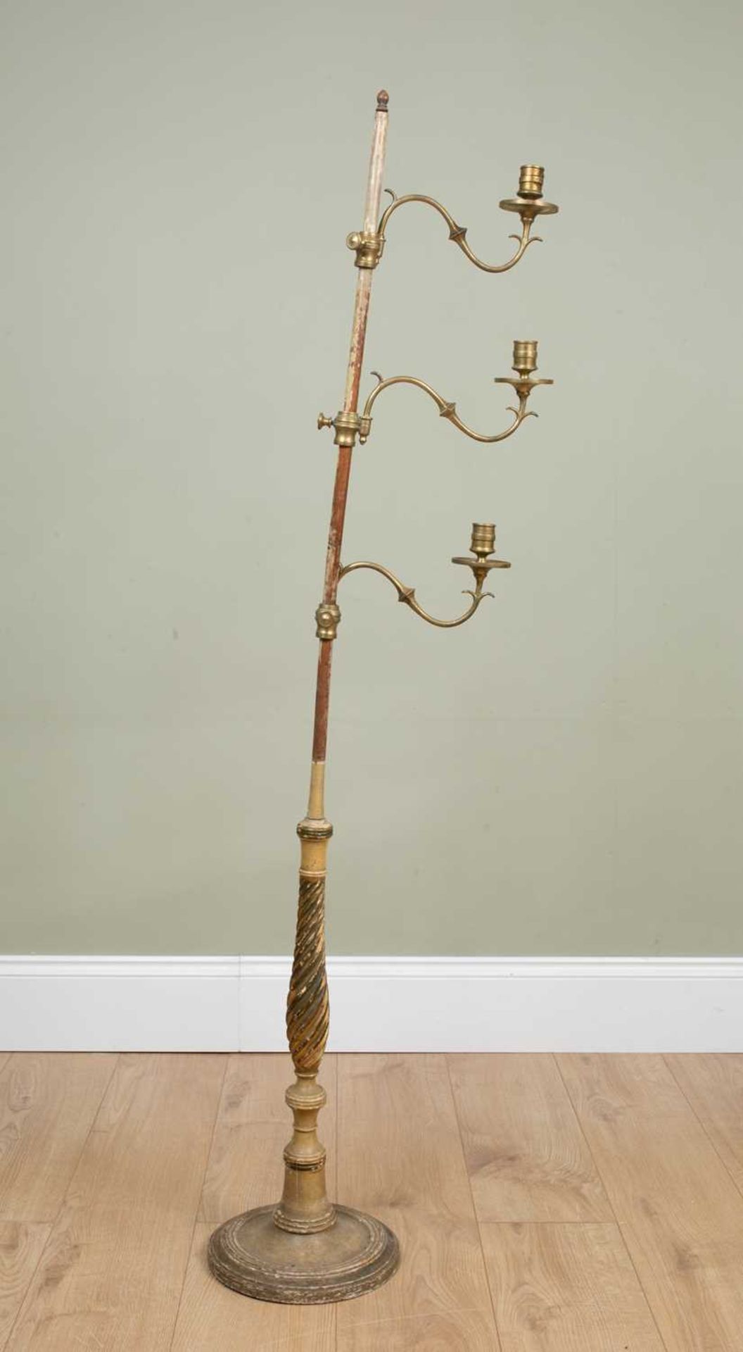 A 19th century painted wooden floor standing candle stand with three adjustable sconces, carved
