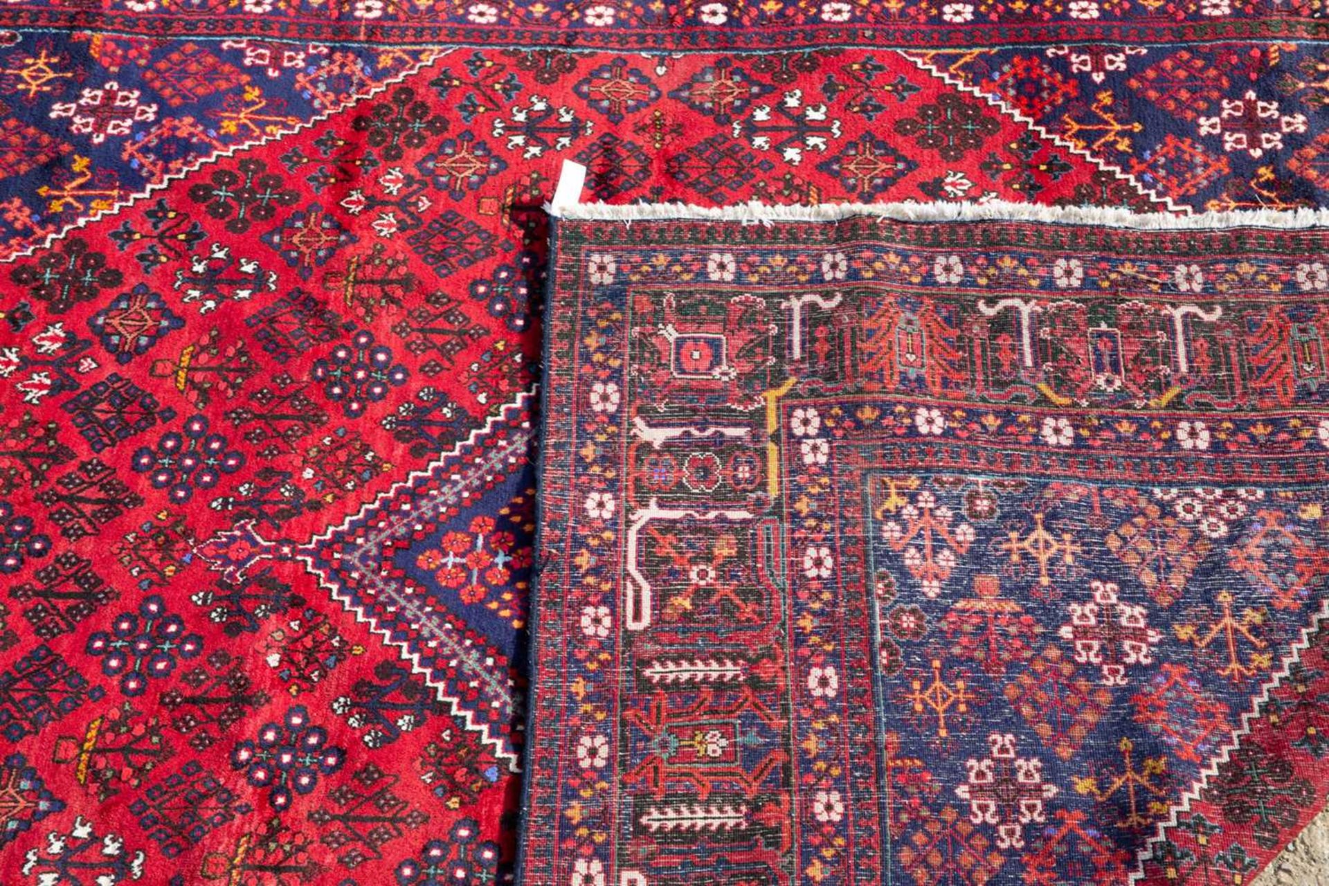 An Oriental red ground large rug with geometric floral designs, 370cm x 278cmMinor marks and wear - Image 2 of 2