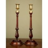 A pair mahogany and brass candle sticks, with fluted stems and circular spreading bases, 39cm