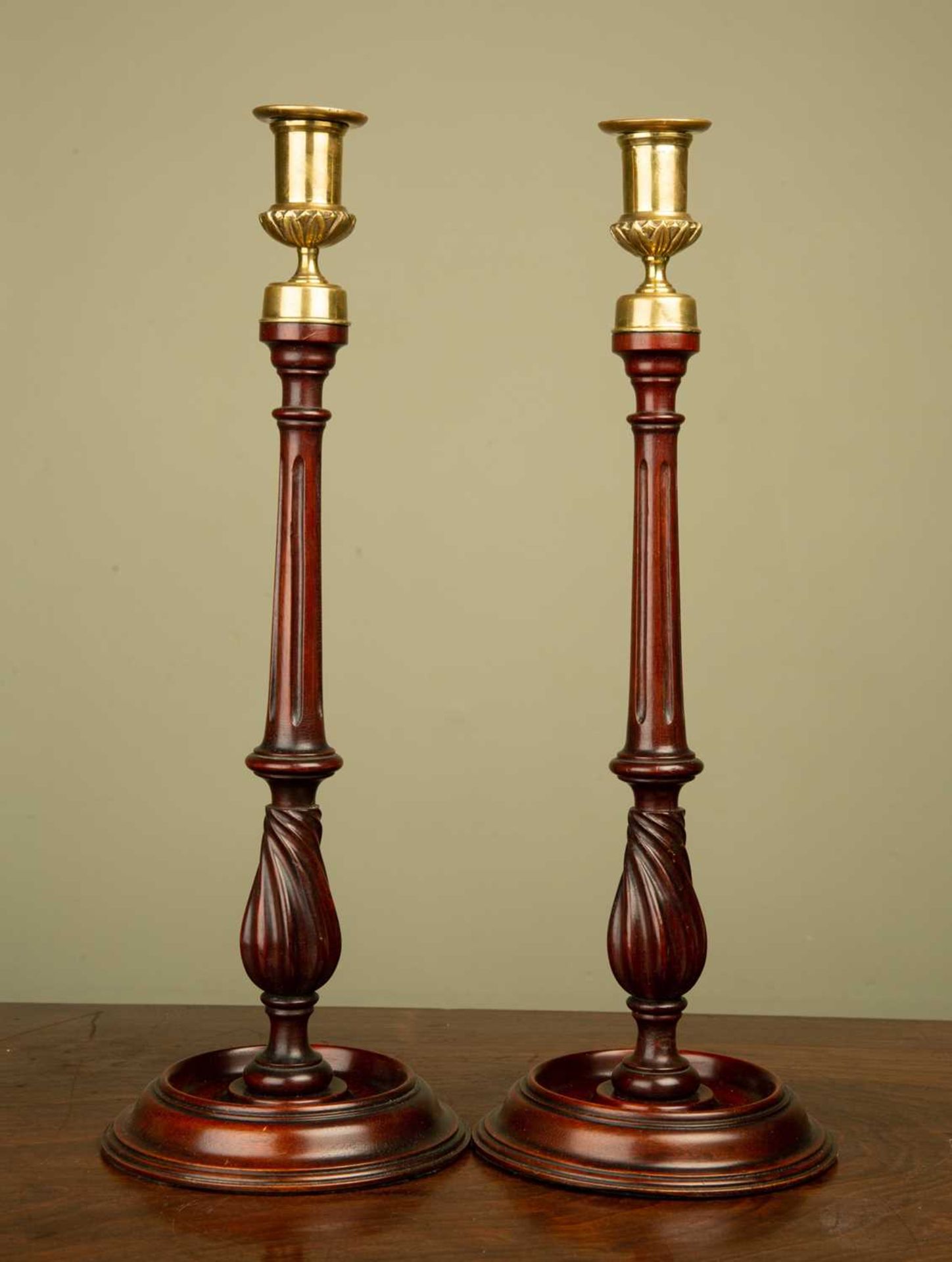 A pair mahogany and brass candle sticks, with fluted stems and circular spreading bases, 39cm