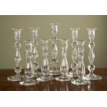 A set of four 19th century glass candle sticks with faceted baluster stems, 21cm high; together with