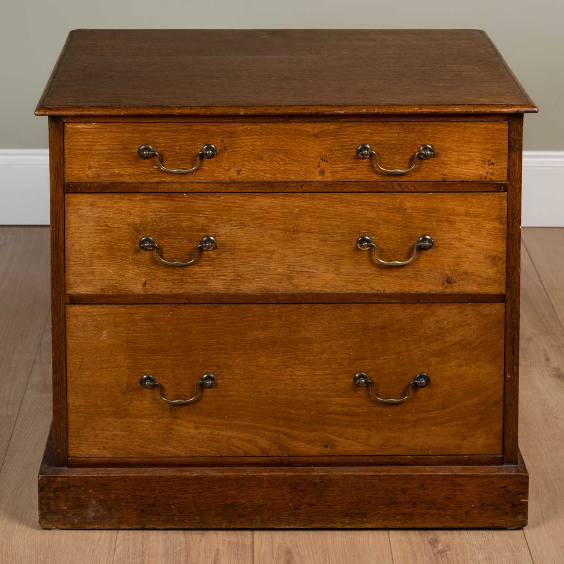 A 19th century oak three graduated drawer chest with swan neck brass handles, on a plinth base, 70cm