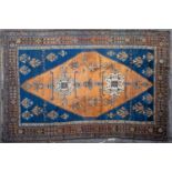 An antique Shiraz brown ground rug with inscription, the central diamond motif on a blue ground