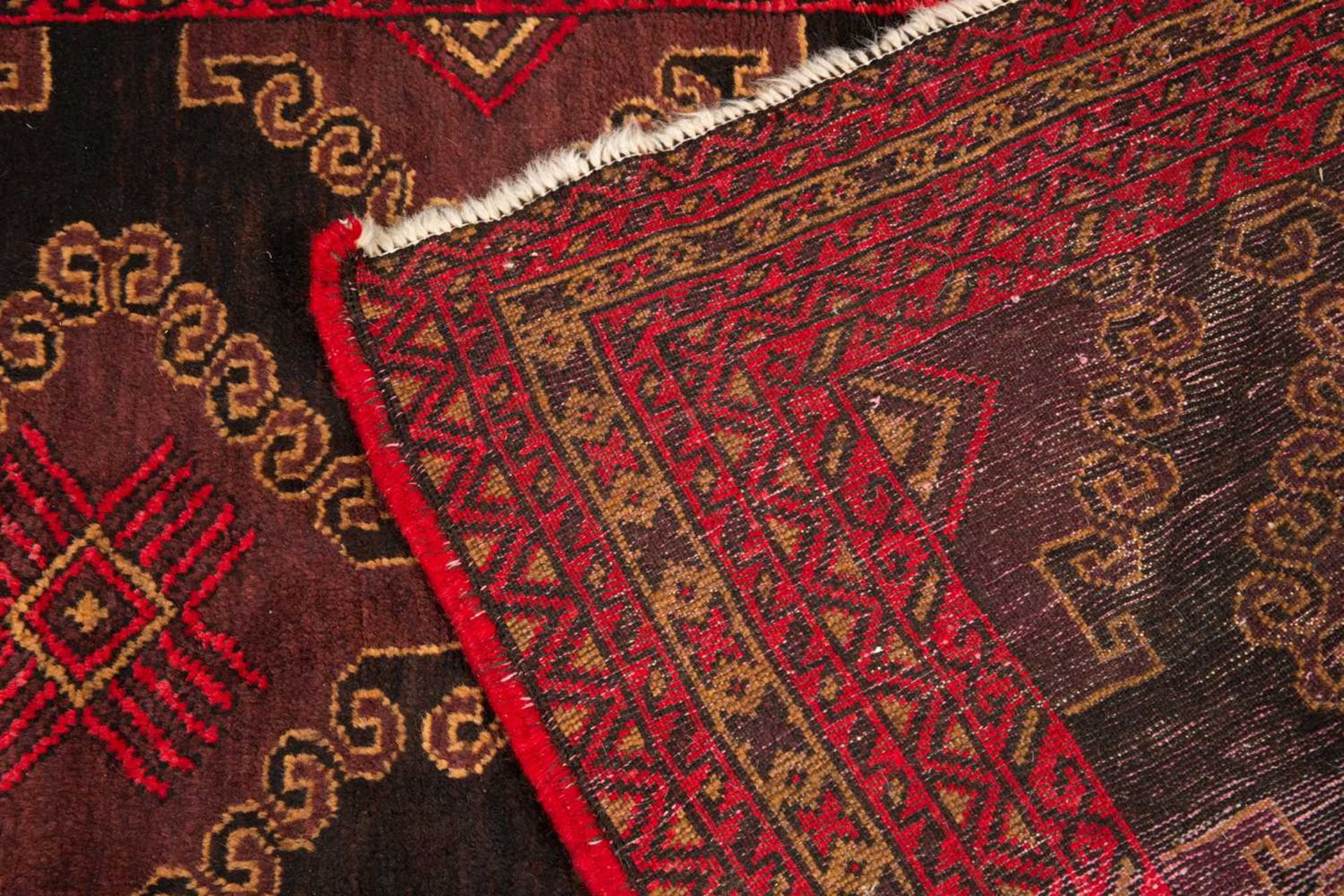 An antique red ground rug with central black ground motif and within a triple banded border, 228cm x - Bild 6 aus 6