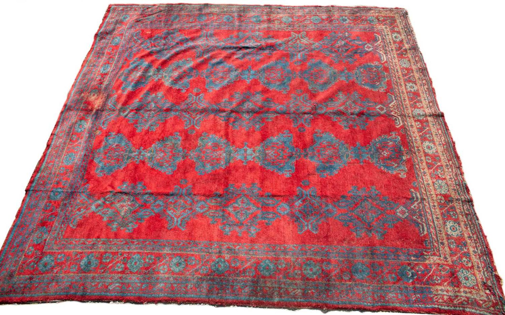 A large red ground Turkey carpet with geometric decoration, 430cm x 407cmStains, marks and minor