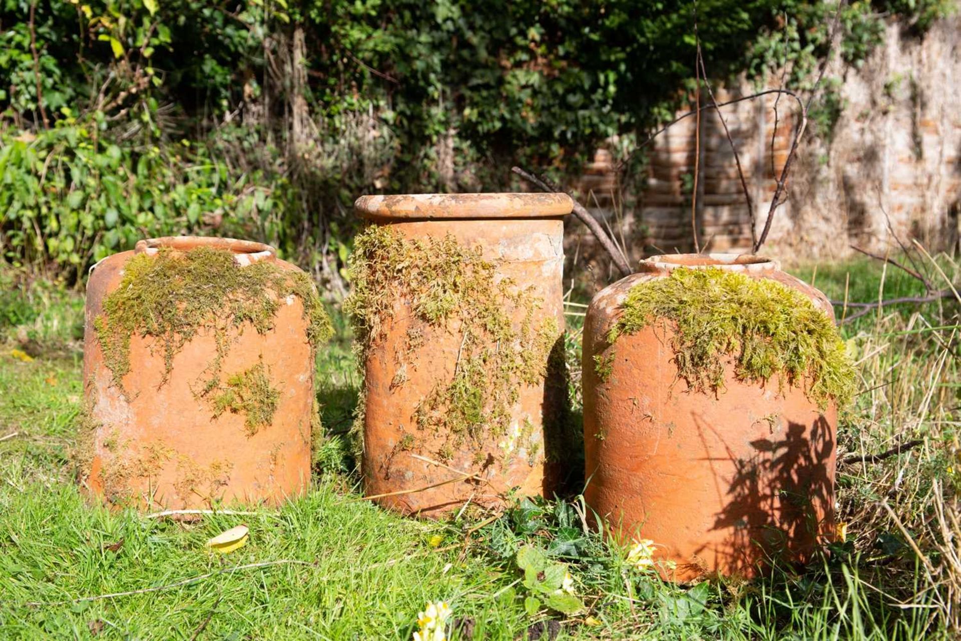 A pair of old terracotta rhubarb forcers and a chimney pot top, the forcers 31cm diameter x 36cm