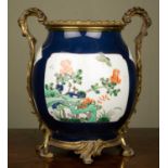 A Chinese porcelain blue ground ovoid vase decorated with cartouches of rockwork, chrysanthemums and
