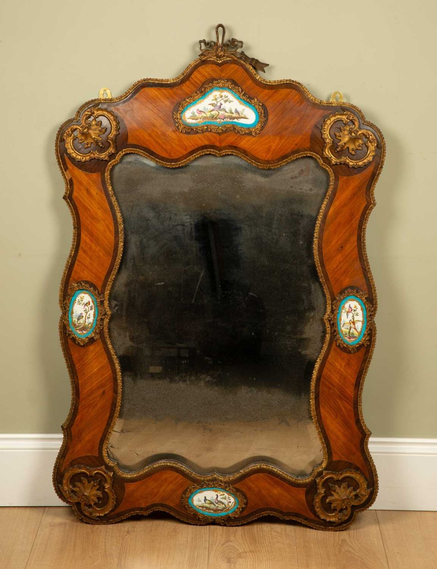 A late 19th/early 20th century French walnut mirror with serpentine frame, gilt ormolu mounts and