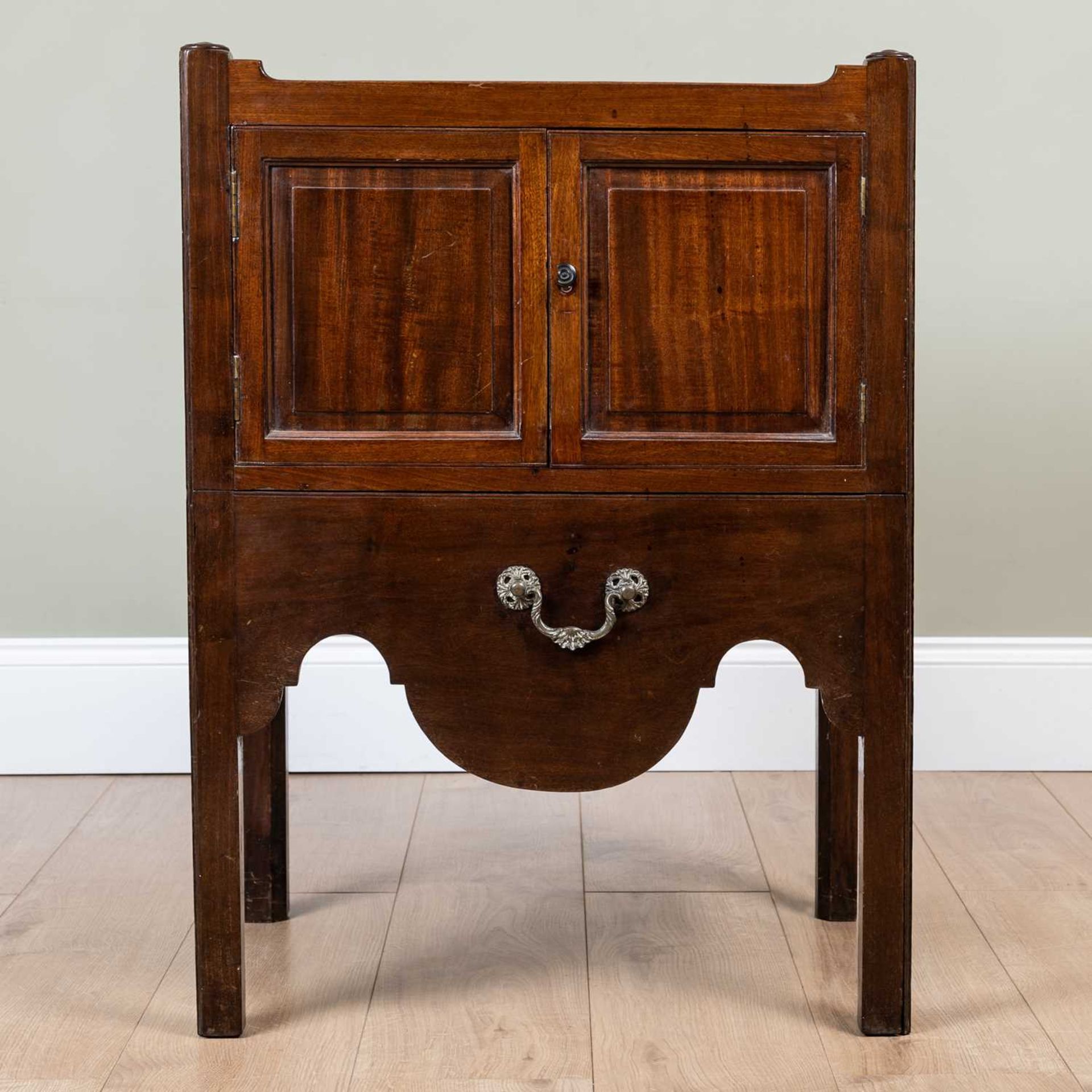 A George III mahogany pot cupboard with galleried top over twin panelled doors and pull out