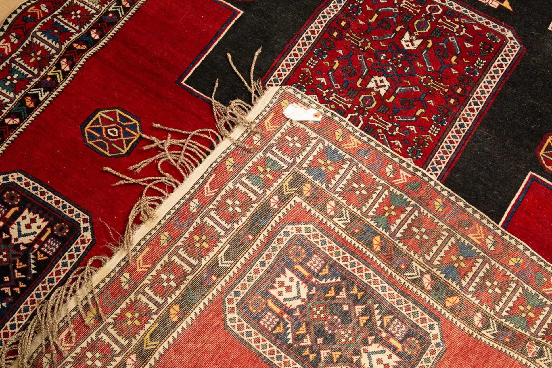 An antique red ground rug with central black ground motif and within a triple banded border, 228cm x - Bild 3 aus 6