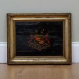 An early 19th century lacquered armorial coach door panel set in a gilt frame, the panel 27cm x 37.