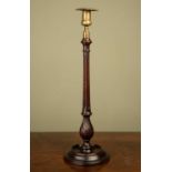 An early 19th century mahogany and brass candle stick with fluted stem and square drip pan, 45cm