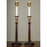A pair of George III-style brass and mahogany table lamps with fluted stems and circular spreading