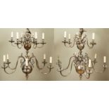 A pair of Dutch-style two-tier twelve-light brass chandeliers with scrolling branches, each