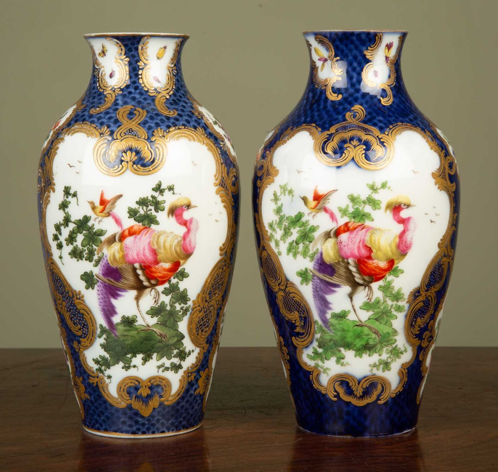 A pair of faux Worcester porcelain baluster vases decorated with exotic birds, probably Sampson,