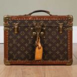 A Louis Vuitton initial monogrammed vanity case with brass metal mounts and brown leather trims,
