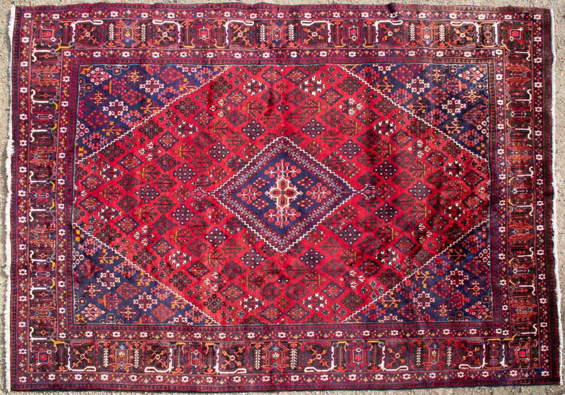 An Oriental red ground large rug with geometric floral designs, 370cm x 278cmMinor marks and wear