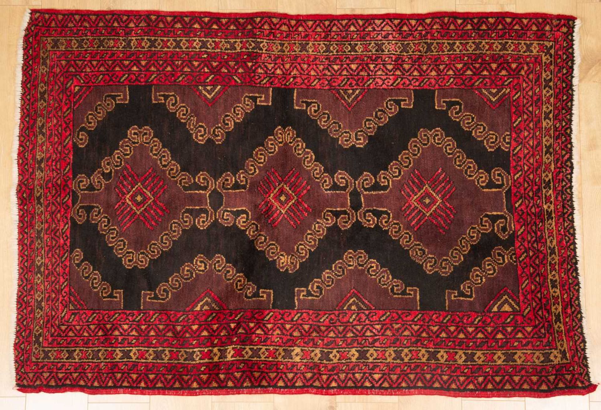 An antique red ground rug with central black ground motif and within a triple banded border, 228cm x - Bild 5 aus 6