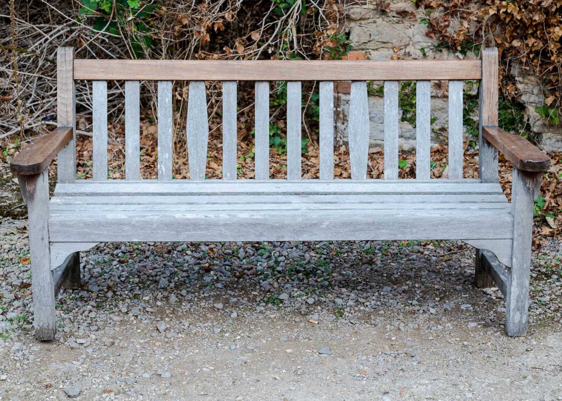 A teak garden bench, 159cm wide x 84cm highWeathered condition, structurally sound.