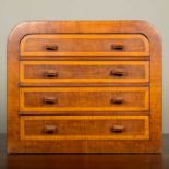 An early 20th century mahogany tabletop chest of four drawers with arching top and crossbanded