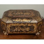 An antique Chinese lacquered work box with canted corners and carrying handles to the side, the