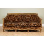 An early to mid 20th century giltwood sofa in the French style with scrolling arm and scrolling feet