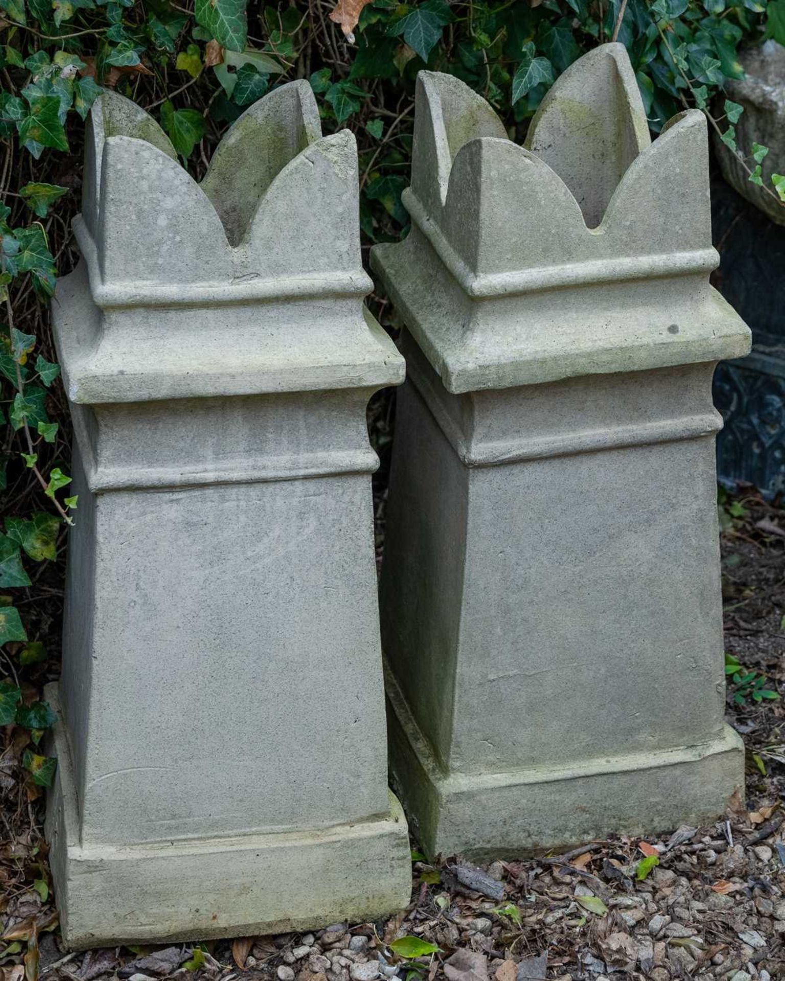 A pair of terracotta chimney pots of square tapering form, on plinth bases, 81cm high overall x 34.