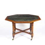 A late Victorian green leather inset octagonal library table with four turned supports united by