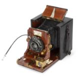An early 20th century James A.Sinclair Una half plate camera with a black leather covered mahogany