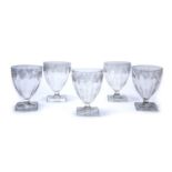 A set of five 19th century wine glasses with vine leaf engraved bowls and square feet, each 9cm