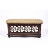 A Victorian aesthetic movement walnut ottoman stool by Lamb of Manchester having an upholstered
