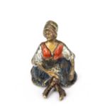 An erotic cold painted bronze of a seated female figure, 4.5cm wide x 5.5cm highSome paint loss