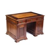 A late 19th century mahogany pedestal desk with a brown leather inset top, three frieze drawers