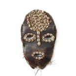 An African hardwood tribal Liga mask, Congo, with shell decoration 39cm x 23cm.