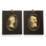 A pair of wax or plaster silhouette portrait miniatures of a young man and woman, both formally