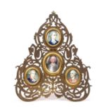 A Family group of four 19th century miniatures painted set in yellow metal mounts and a gilt frame