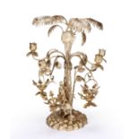 A white metal table centrepiece of palm tree design with four branching candle sconces above a