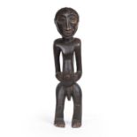 An African carved wood Senufo male figure 20cm wide 78cm high.