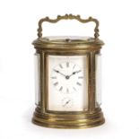 A 19th century French oval brass carriage clock, the white enamel Roman dial with subsidiary alarm