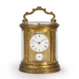 A 19th century French oval gilt brass carriage clock, the circular white enamel Roman dial over a