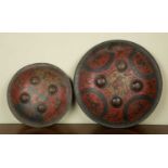 Two red Mughal war shields with painted animal and foliate decoration and applied roundels, the