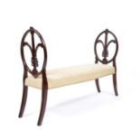 A George III style mahogany framed window seat, the carved ends with Prince of Wales feathers,