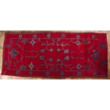 Red ground rug Turkish, 20th Century decorated with floral emblems, 274cm x 115cmAt present, there